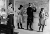 1907 classroom with students writing on chalkboard
